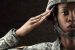 A Black woman veteran salutes in a military uniform.