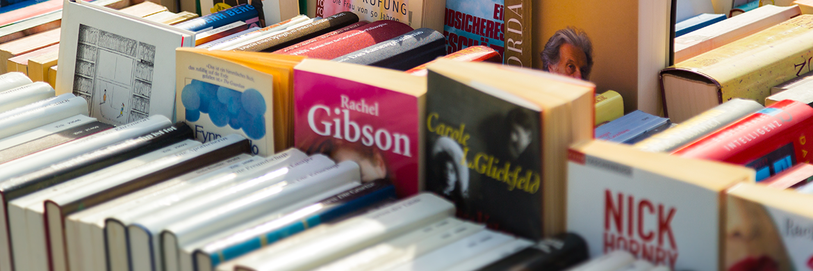 Various books stacked up at a book sale