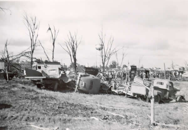 Line of 3 crushed pick-up trucks. 