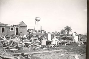 Field of debris with water tower in background.