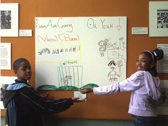 Two children standing in front of white board. 