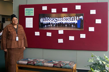 Diane standing on front of Power of Song exhibit bulletin board. 
