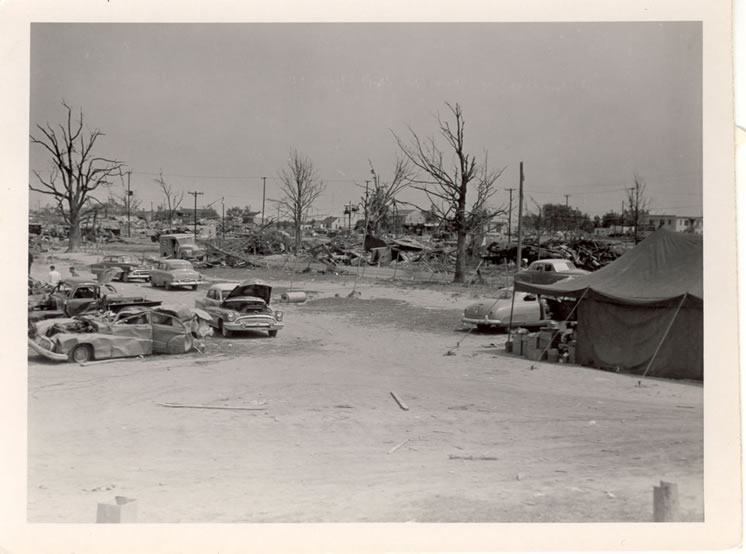 Field of debris and Red Cross tent. 