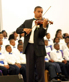 Man playing violin in front of choir.