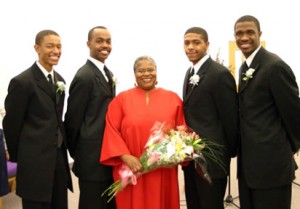 Group photo with woman in red holding flowers. 