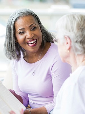 A picture of a woman smiling while discussing a book
