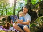 A parent reading to their child outdoors 