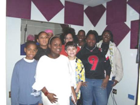 Group of kids standing in recording studio.