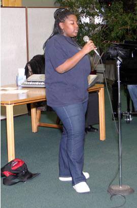 Young woman singing solo in choir rehersal.