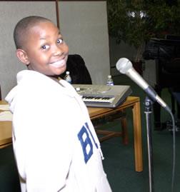 Black boy smiling in front of microphone.