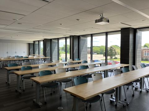 Photo of large meeting room with tables and chairs in Classroom set-up