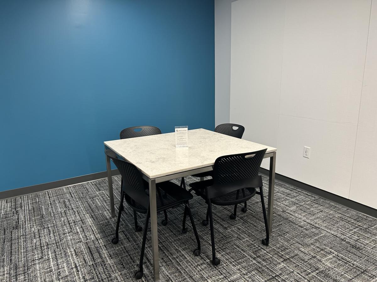 Study Room with four desk/rolling chairs and table.